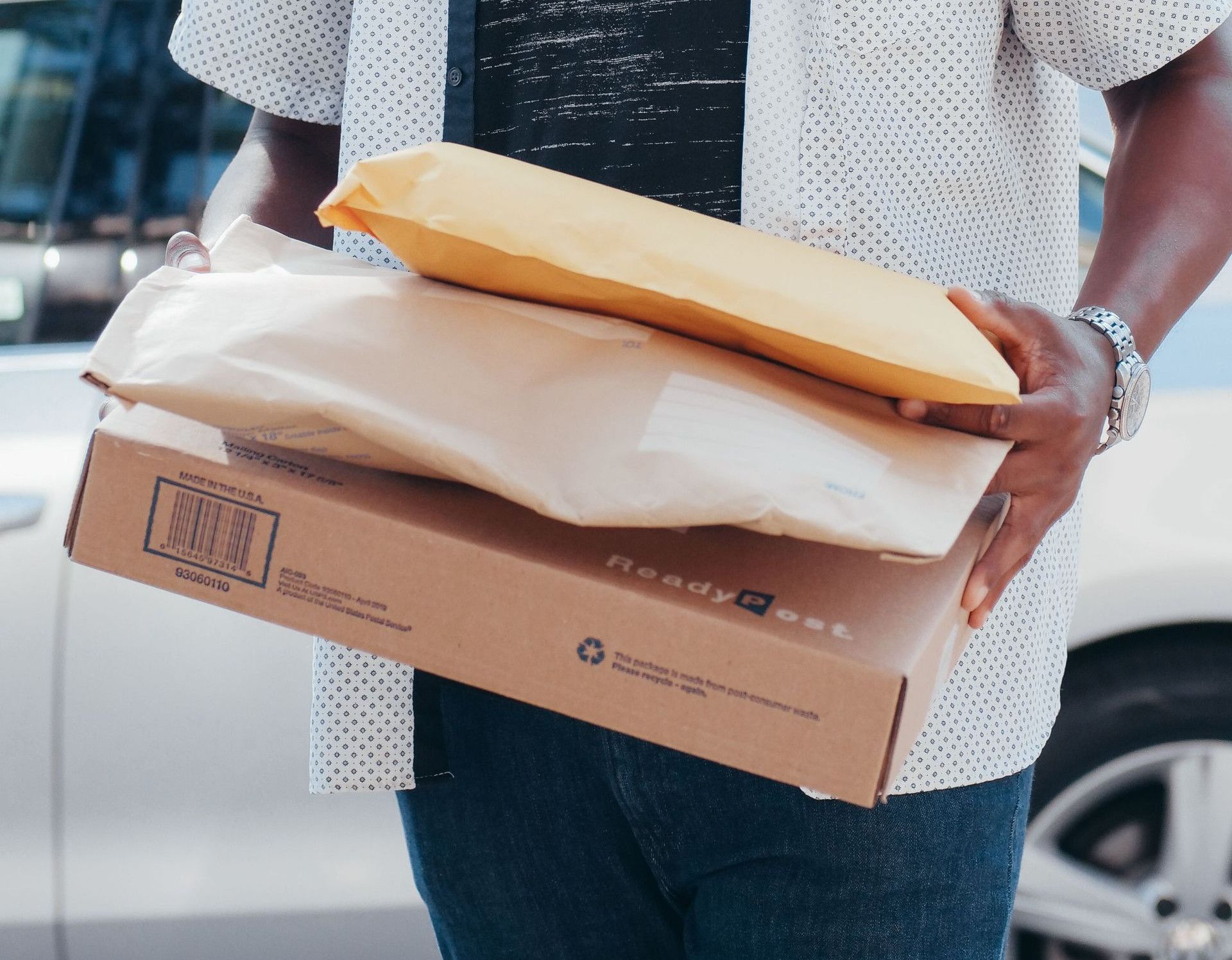 A deliveryman carrying packages outside, showcasing modern online shopping convenience.